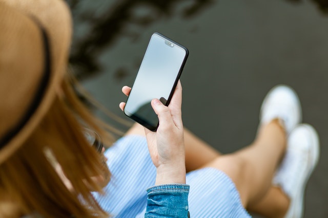 person holding smartphone white sitting 1310532