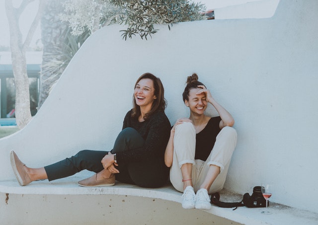 two women sitting on white bench 1549280